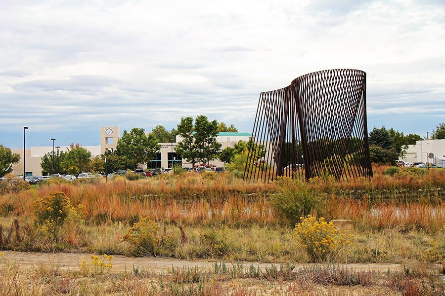 The energy sculpture is shown in the foreground with the clocktower building in the background.